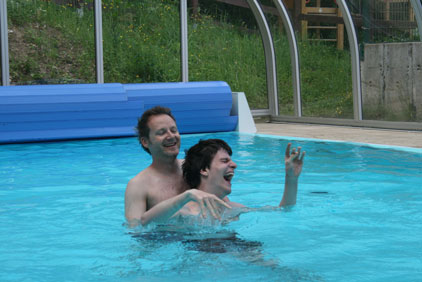 Pascal hat viel Spaß im Schwimmbecken und spritzt mit Wasser um sich.
