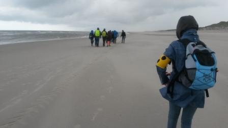 Die Klasse wandert am Strand entlang. Amanda verfolgt die Gruppe.