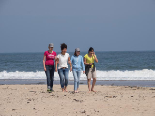 Michelle, Frau Geray, Melissa und Pariza wandern durch den Sand zum Meer