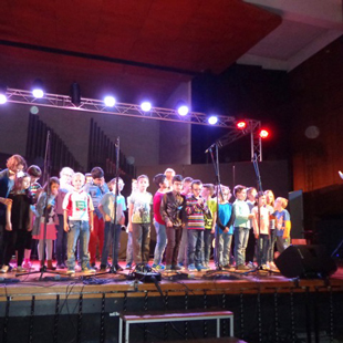 Der große Chor - bestehend aus Grundschülern aus Birkesdorf und Schülern der Louis-Braille-Schule - steht auf Bühne.