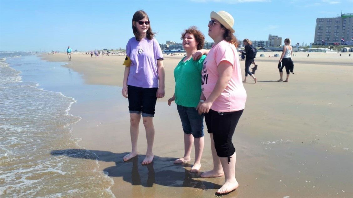 Jacky, Alina und Selin gehen mit den Füßen ins Meer.