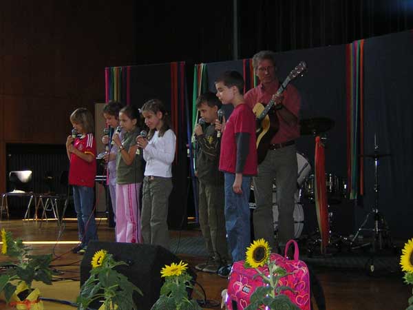 Die Grundschulband 'Fidibus' auf der Bühne. Herr Großnick begleitet auf der Gitarre.