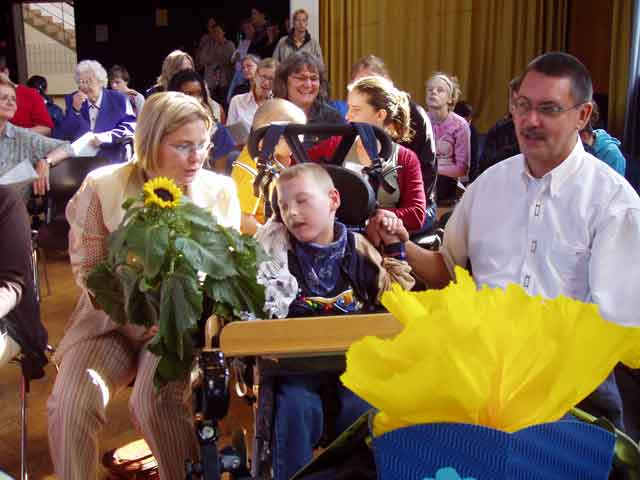Tim-Simon betrachtet mit seinen Eltern die Sonnenblume