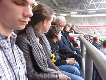 Im Stadion verfolgen Andreas und Miro über Kopfhörer das Fußballspiel.